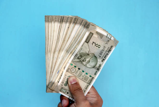 istock Man Hand holding Rupees 500 bank note savings 1476085292
