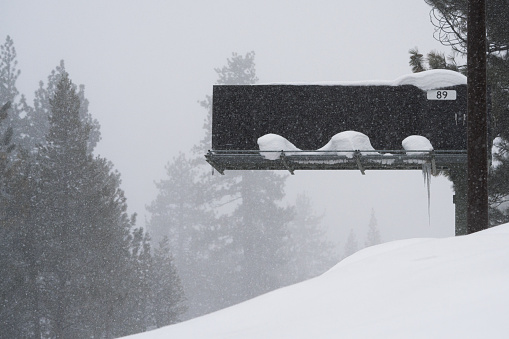 Blank highway digital sign in Sierra Nevada mountains during winter storms.