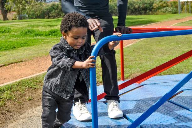 istock young black African boy playing with his father on a swing 1476087747
