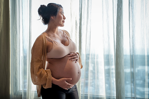 Pregnant woman feels happy at home while caring for her baby in the womb, woman pregnancy concept