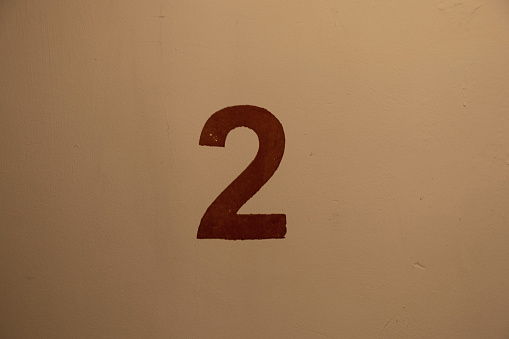 the red number two is painted on the wall of the staircase on the second floor