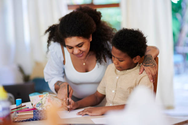Learning, family home and mother with child education, teaching and happy writing development. Black woman, mom with kid for language, creative knowledge and support, helping or kindergarten homework