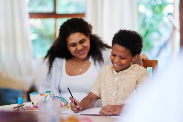 istock Help, writing and mother with child doing homework, studying and learning in homeschool. Happy, support and mom helping son with education, drawing or alphabet lesson at a home desk together 1476098516
