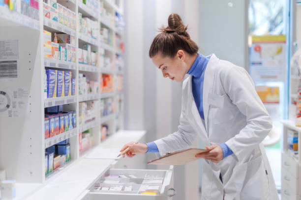 istock Young pharmacist checking medicine stock in pharmacy. 1476106842