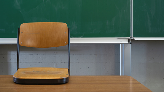 School classroom background - Empty classroom with school blackboard, teacher's desk and raised chair