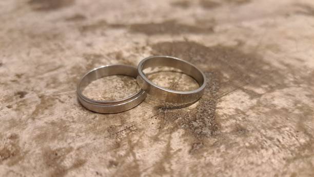 istock Silver wedding rings on sepia cement floor 1476112420