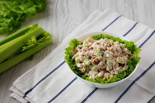 Homemade Chicken Salad with Lettuce in a White Bowl, low angle view.