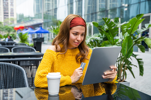 Young woman using a digital tablet while relaxing outdoors.
