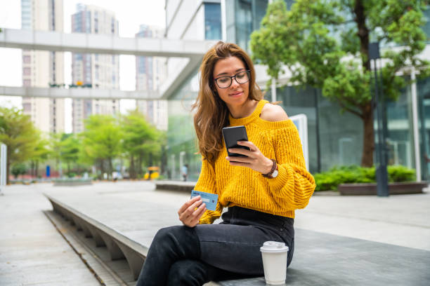 istock Girl holding credit card and texting 1476118668