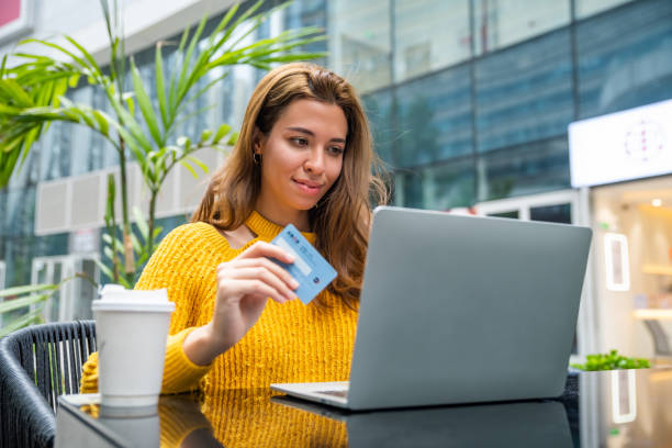 istock Young woman using her laptop to make an online payment using her credit card 1476118931