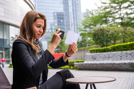 Beautiful Young Woman Depositing Check With Smartphone