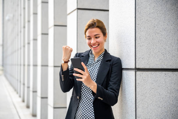istock Beautiful Latin Woman Using Smartphone, Celebrating Successful Victory with Yes Gesture 1476119344