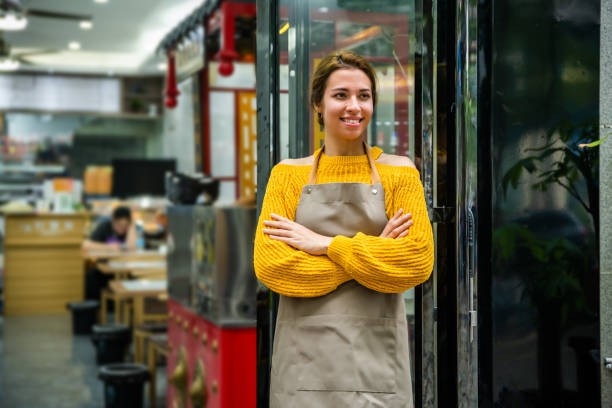istock Small business owner standing at cafe entrance while looking away. 1476119860