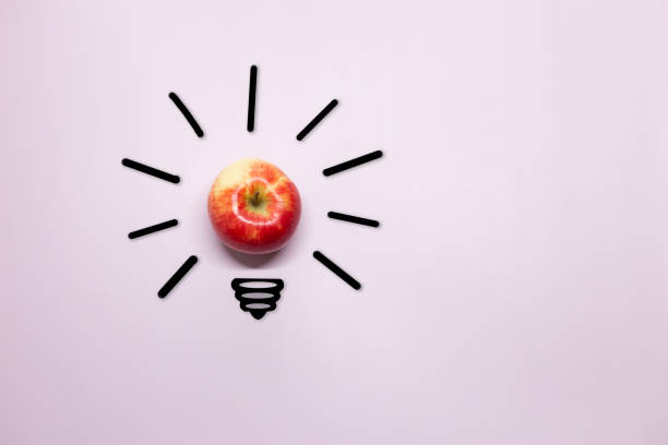 istock Creative thinking ideas and innovation concept. A ball of apple with a light bulb symbol on a purple background. Time for a healthy diet. 1476126384