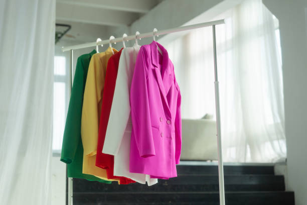 istock Multi-colored bright jackets on a hanger against the background of the window. 1476128875