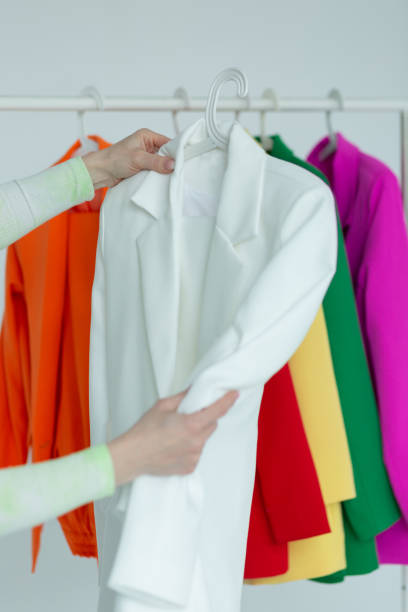 istock A woman's hands chooses clothes on a hanger on a white background. 1476129036