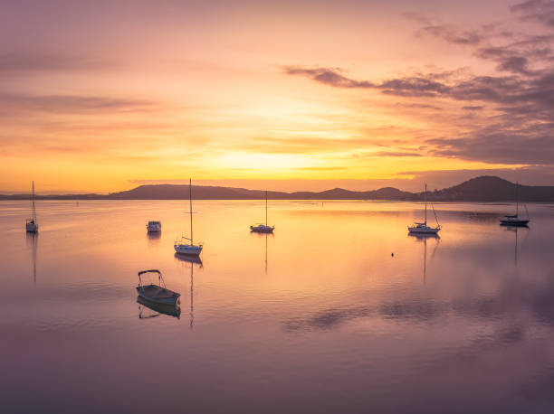 istock Aerial sunrise waterscape with boats and high cloud 1476131349