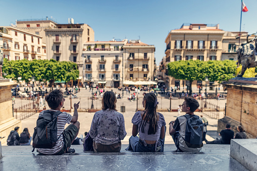 Family sightseeing Palermo, Sicily, Italy. Sunny spring day in Italy. Mother and three teenagers are sitting on the stairs of Teatro Massimo and looking at the Piazza Verdi.
Canon R5