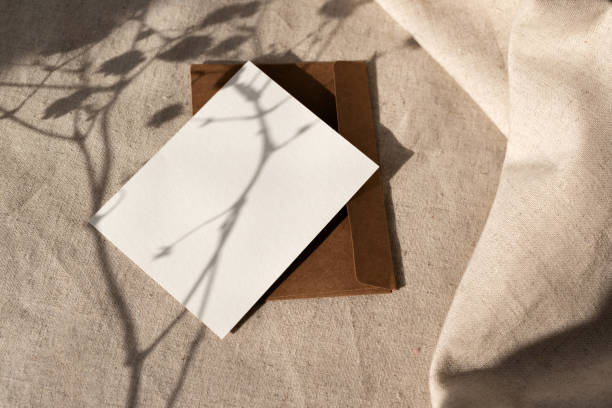 istock Empty paper card and envelope with aesthetic harsh floral sunlight shadows on neutral beige linen background, natural boho business brand template with mock up copy space 1476138745