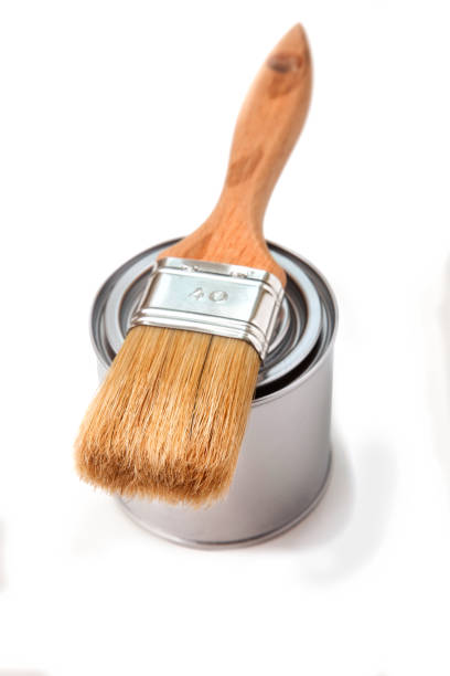 istock large paintbrush on unopened silver paint can against white background 1476139260