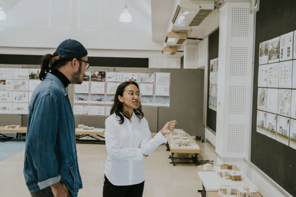 istock Asian architects partner, consult and discuss about exhibition of architecture student's thesis work for sustainable design subject 1476147738
