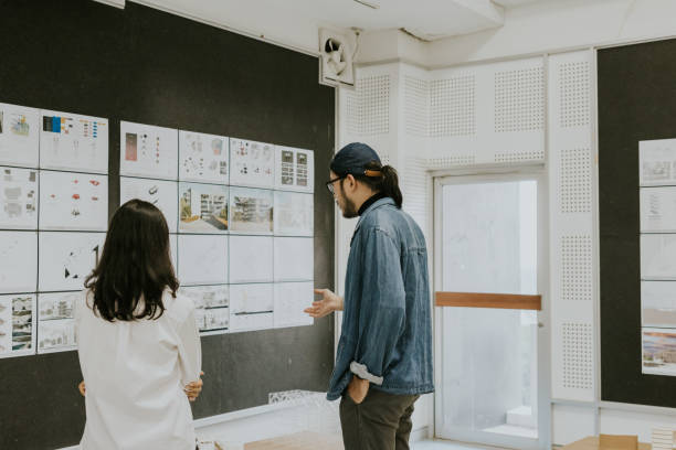 istock Asian architects partner, consult and discuss about exhibition of architecture student's thesis work for sustainable design subject 1476148269