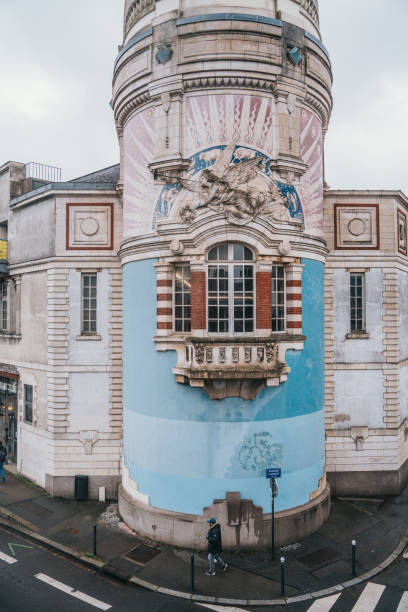 March 8th 2023, Nantes Brittany France: Locals walking on the street in Nantes, which is one of the most popular cities to tourists in France. A historic tower can be seen in the image.