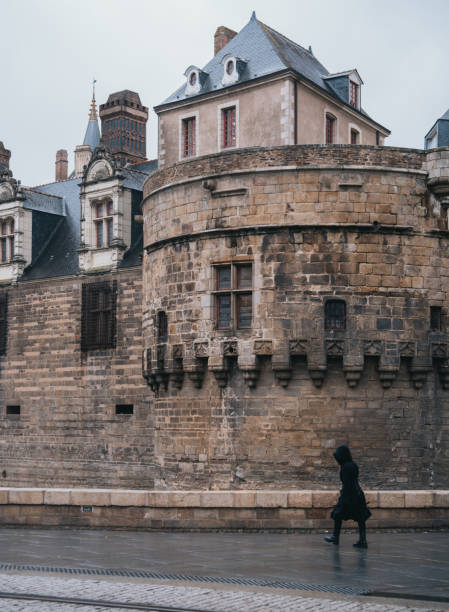March 8th 2023, Nantes Brittany France: Locals walking on the street in Nantes, which is one of the most popular cities to tourists in France. Château des ducs de Bretagne can be seen in the image.