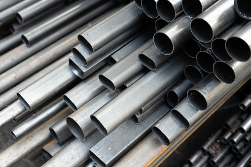 Stack of steel pipes. Close - up of stack of metal pipes. Industrial elements closeup. Parts stacked for further processing.