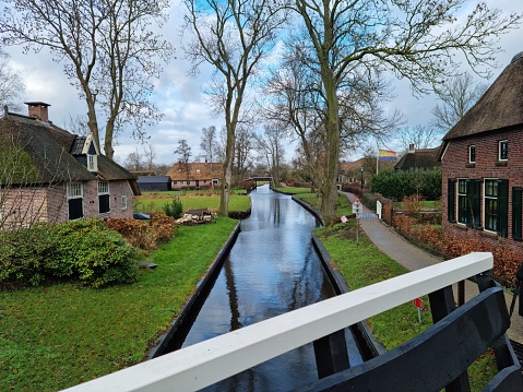 Typical rural scenery in Giethorn with canal river, street, trees and house