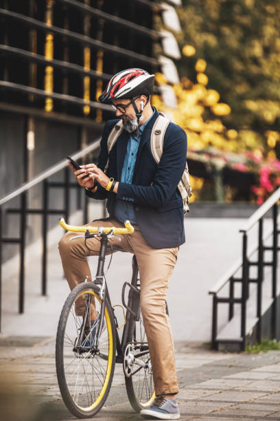 istock A Businessman Using A Smartphone While Traveling To Work With A Bike 1476174884