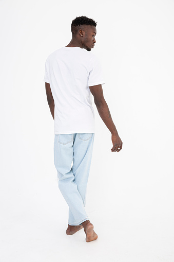 Black man of African descent wearing a white t-shirt. Expressionless. isolated on white.