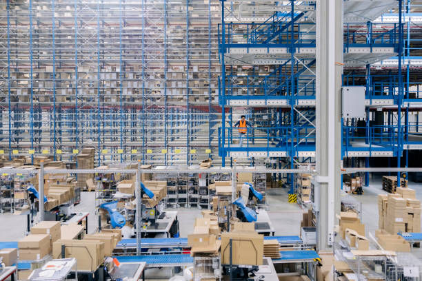 istock Interior of a large distribution warehouse company with worker standing in balcony 1476175412