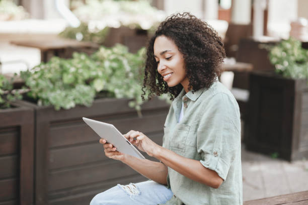 istock Happy woman using digital tablet in a city 1476176286