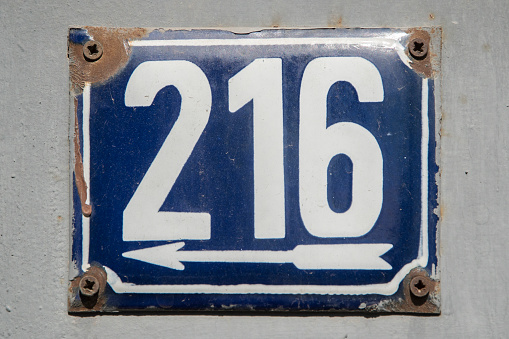 Weathered grunge square metal enameled plate of number of street address with number 216