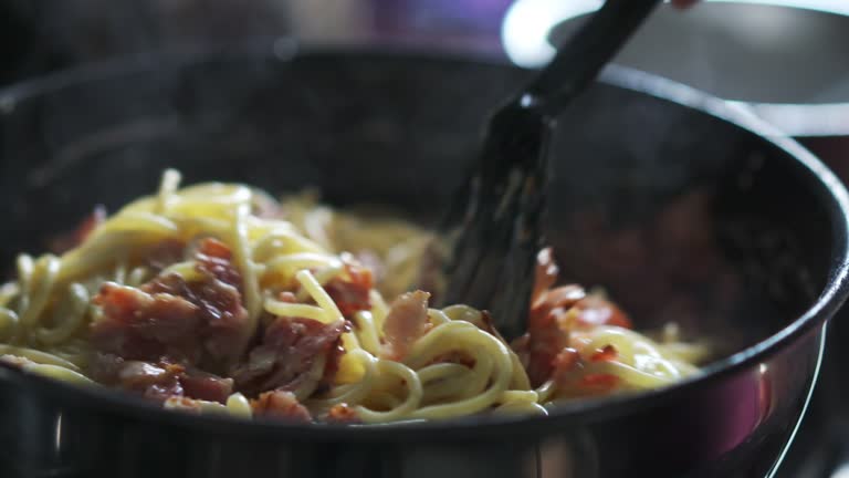 spaghetti carbonara with bacon mixing in 180fps slow motion