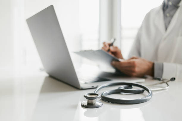 istock Physician, therapist or practitioner filling medical form document, focus on stethoscope 1476184364