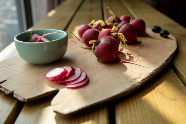 A plate of chopped carrots is on the wooden table