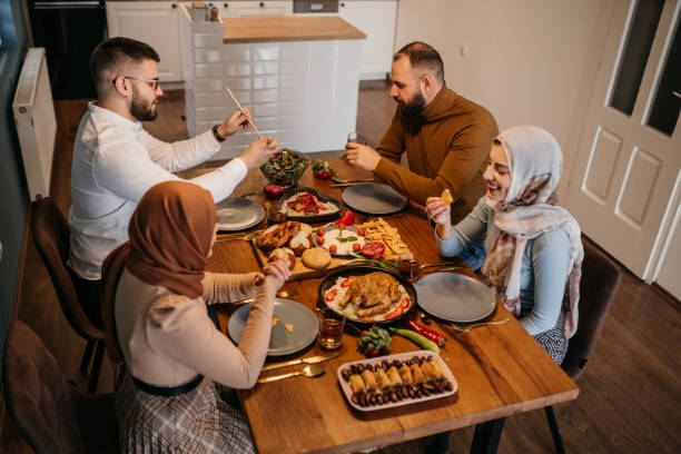 istock High-angle view of two Muslim couples sitting together while enjoying a meal in celebration of Ramadan 1476194487
