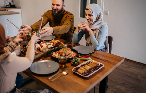 istock High-angle view of two young couples sitting together while enjoying a meal in celebration of Ramadan 1476194508