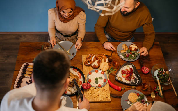 istock High-angle view of two young couples sitting together while enjoying a meal in celebration of Ramadan 1476194606