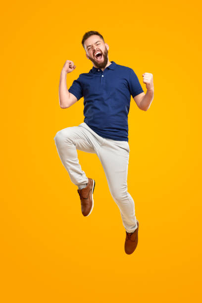Excited man celebrating success and jumping high stock photo