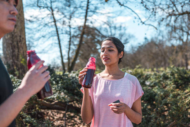 pareja deportiva asiática bebiendo botellas de agua sostenibles después de un entrenamiento - 16710 fotografías e imágenes de stock