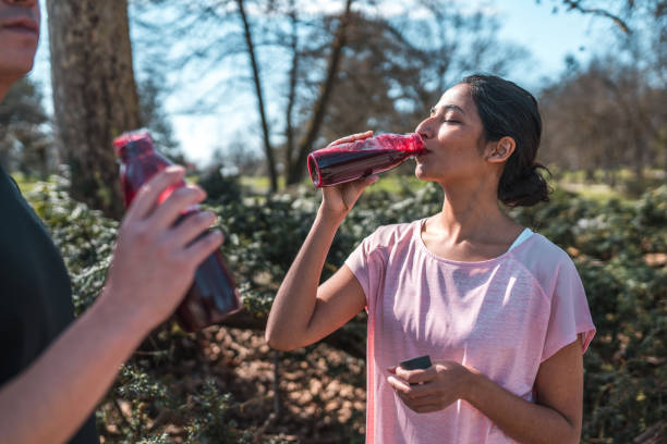 トレーニング後に持続可能な水のボトルから飲むアジアのスポーツカップル - 16711 ストックフォトと画像
