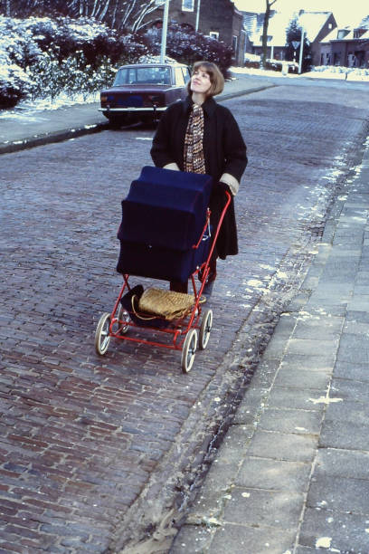 Young mother walking with her just born baby in a carriage