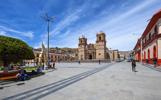 Puno, Peru, November 18, 2021: Panoramic view of the Plaza Mayor in Puno with the catholic Puno Cathedral (Catedral Basílica San Carlos Borromeo) from 18. century in the morning. The cathedral is built in the Andean Baroque architectural tradition, and is the seat of the Roman Catholic Diocese of Puno.