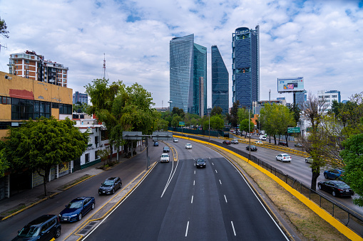 Mexico City Mexico - February 13 2022: Cars Driving Down the Freeway with Skyscrapers in the Background in Mexico City Mexico