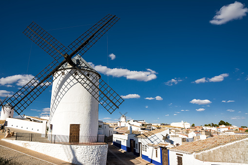 Ancient windmills near houses in Campo de Criptana, Spain, defined in Cervantes' Don Quixote \