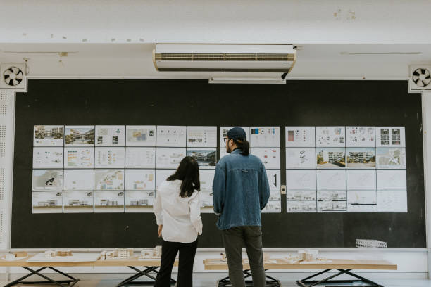 istock Student's work exhibition, Asian architect professor is brainstorming and sharing ideas about final exam thesis of sustainable design of master'd degree project 1476230156
