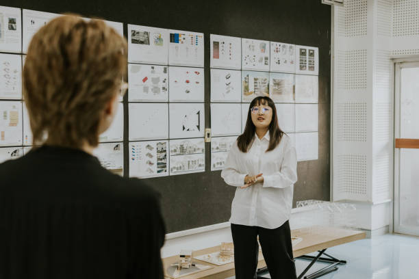 istock Two asian friends who studying in architecture together, practicing presentation of her blueprint work before presenting to professor. 1476230221